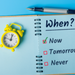 Retro alarm clock and a notebook with a the headline When? Putting Off Estate Planning