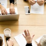 people around a table negotiating - 5 stages of mediation