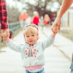 child holding parents hands - 5 things to include in your parenting agreement