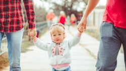 child holding parents hands - 5 things to include in your parenting agreement