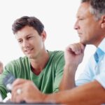 Son and father sitting by a computer - a post on child support and post secondary education in Ontario from Kelly D Jordan Family Law.