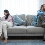 Couple sitting on opposite ends of a sofa - do you have to separate for a year before divorce, with insights from Kelly Jordan Family Law.