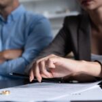 Faceless couple with woman placing rings on divorce papers - uncontested divorce in Ontario - Kelly Jordan Family Law.