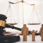Paper cutout family with gavel and scales - family law legal support with Kelly Jordan Family Law.
