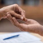 Faceless couple’s hands with woman placing wedding ring in the man’s hand - insights on marriage annulment steps from Kelly Jordan Family Law.