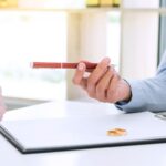 Faceless person handing another one a pen with agreement between them - what if a spouse won’t sign a separation agreement - insights from Kelly Jordan Family Law.