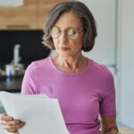 Woman looking at papers - what to do when served divorce papers with insights from Kelly Jordan Family Law.